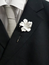 Load image into Gallery viewer, May include: A white flower lapel pin with rhinestones, attached to a black suit jacket with a white shirt and a grey tie.