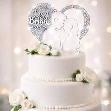 Load image into Gallery viewer, May include: A white, three-tiered wedding cake adorned with white roses and a heart-shaped cake topper. The topper displays the names "Jusy" and "Brian" with the date "09.09.25" and a couple's silhouette.
